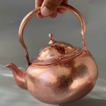 Gehamerde koperen theepot met ingebouwd filter