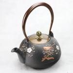 Gietijzeren theepot met bloemen en vogel