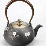 Gietijzeren theepot met bloemen en vogel