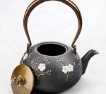 Gietijzeren theepot met bloemen en vogel