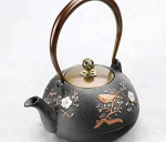 Gietijzeren theepot met bloemen en vogel