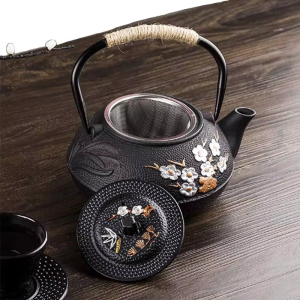 Gietijzeren theepot met filter en bloemendecor