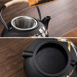 Gietijzeren theepot met filter en bloemendecor