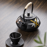 Gietijzeren theepot met filter en bloemendecor