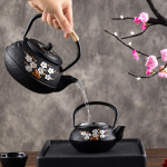 Gietijzeren theepot met filter en bloemendecor