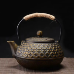 Gietijzeren theepot met reliëfmotieven