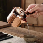 Koperen theepot met houten handvat en hamerslag