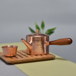 Koperen theepot met houten handvat en hamerslag