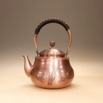Koperen theepot met vissen en gravure