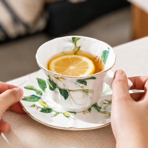 Porseleinen koffiekopje met schotel en camelliadecor