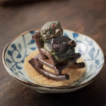 Tea pet kikker in een schommelstoel