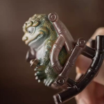 Tea pet kikker in een schommelstoel