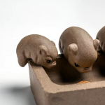 Tea pet met vier varkentjes van paarse klei