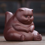 Tea pet van paarse klei in kattenvorm