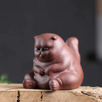 Tea pet van paarse klei in kattenvorm