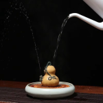 Tea pet van paarse klei met waterstraal