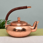 Vintage koperen theepot met hamerslag en gevlochten hengsel
