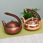 Vintage koperen theepot met hamerslag en gevlochten hengsel