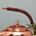 Vintage koperen theepot met hamerslag en gevlochten hengsel
