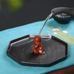 Zittende tea pet monnik van aardewerk